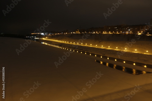 Night and walkway full of lights near the river in winter day