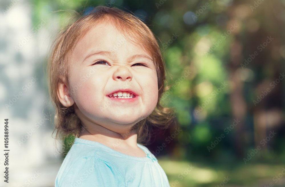 Happy toddler girl smiling outside