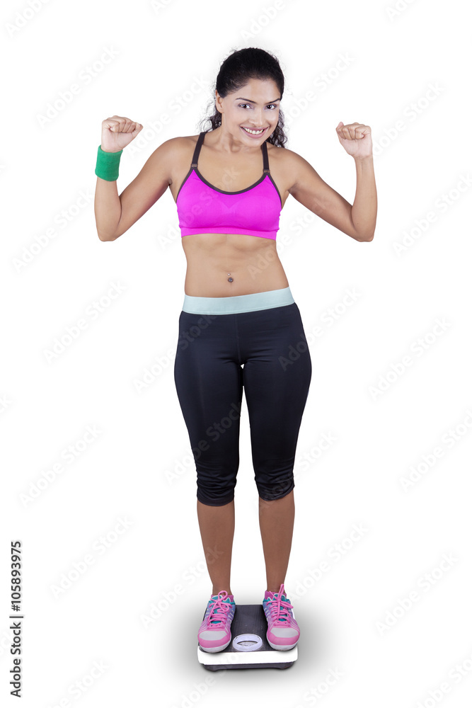 Excited woman stands on weighing scales Excited woman stands on weighing scales