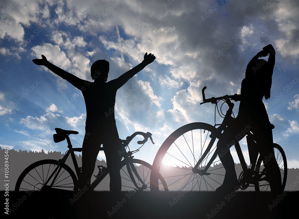 Fototapeta premium Two cyclists on a bicycle in the sunset