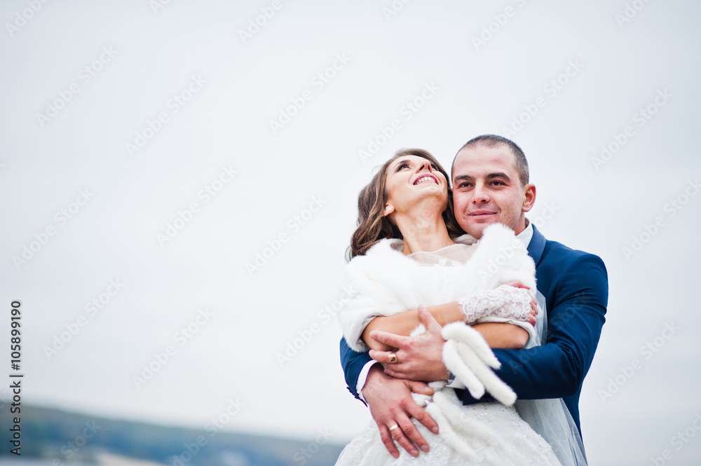 Close up wedding portrait of couple in cloudy weather on the bac