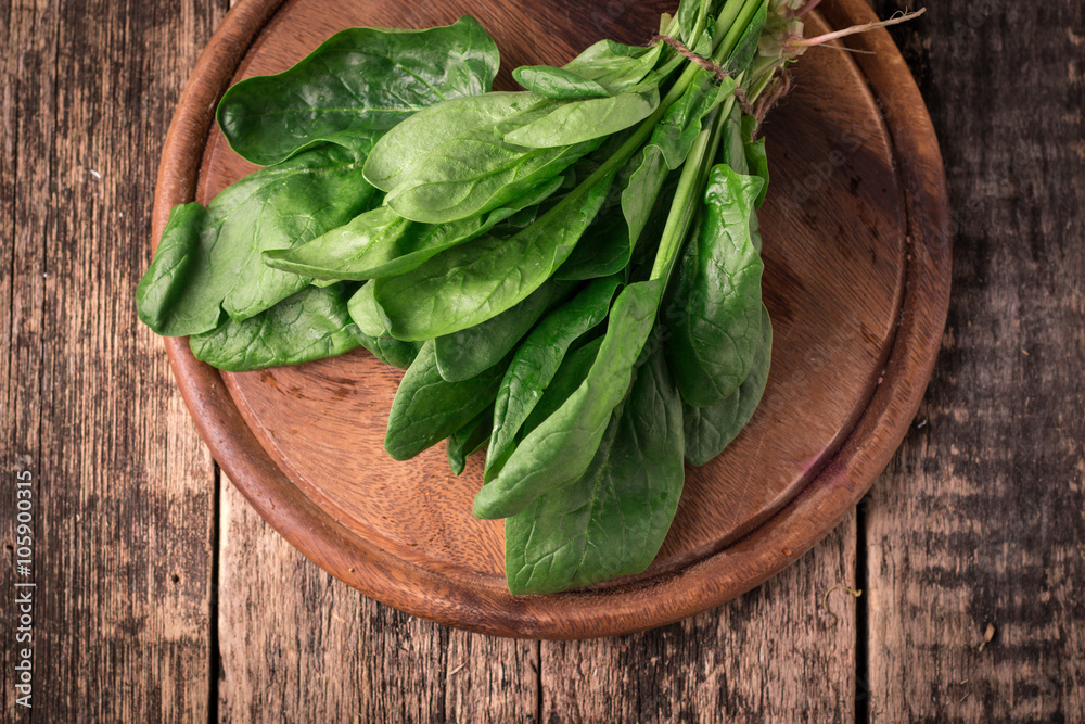 Bunch of fresh spinach with roots over old wooden surface. Dark rustic style Bunch of fresh spinach with roots over old wooden surface. Dark rustic style