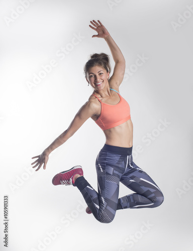 Красивая молодая девушка в спортивной одежде прыгает 