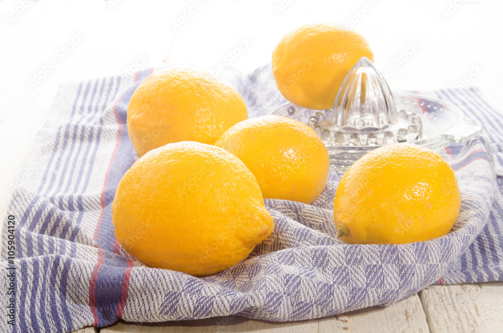lemons and lemon squeezer on a kitchen towel lemons and lemon squeezer on a kitchen towel