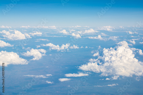 Clouds in blue sky, aerial view from airplane window.