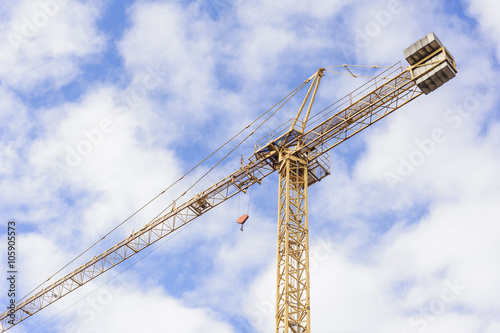 Yellow Industrial Crane Against Blue Sky