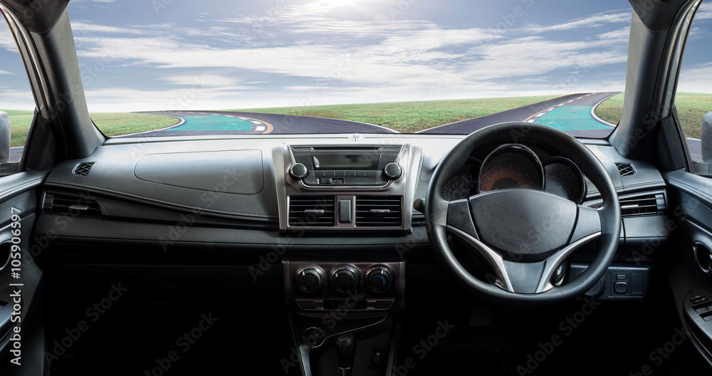 Car dashboard speeds while on road curve and sky background.