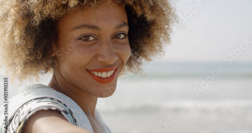 Tableau sur toile Young african american girl beckoning to come on a tropical beach