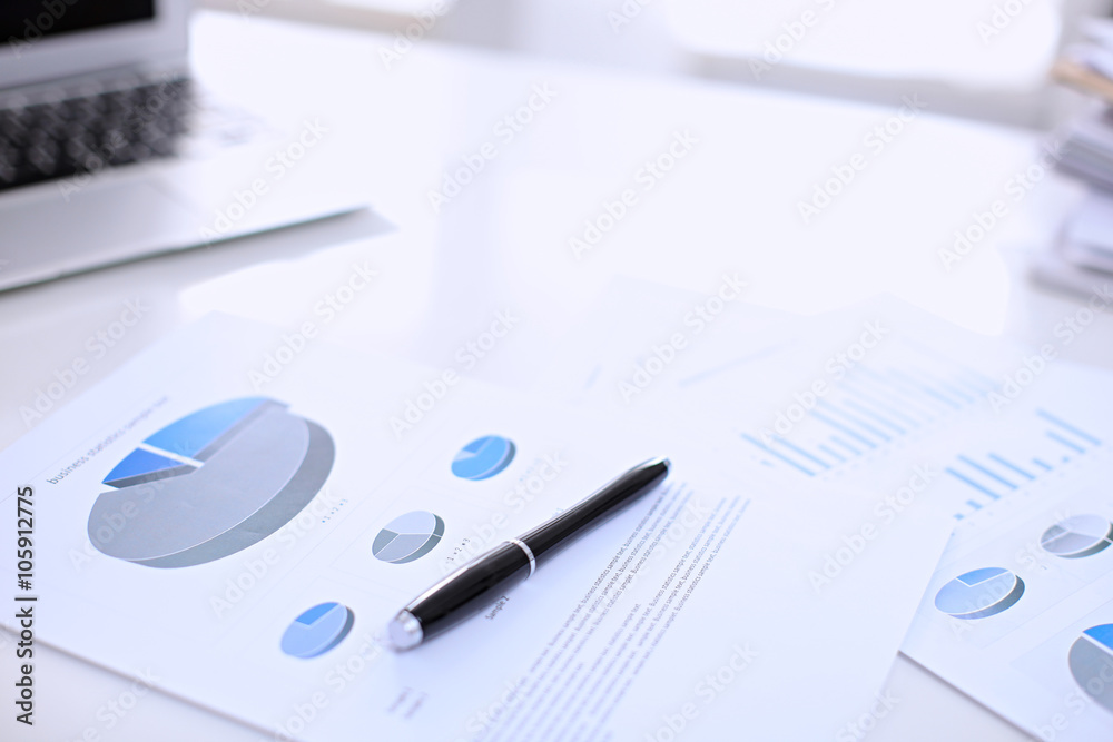 Fototapeta premium .Office workplace with a laptop and financial documents on the light reflecting table
