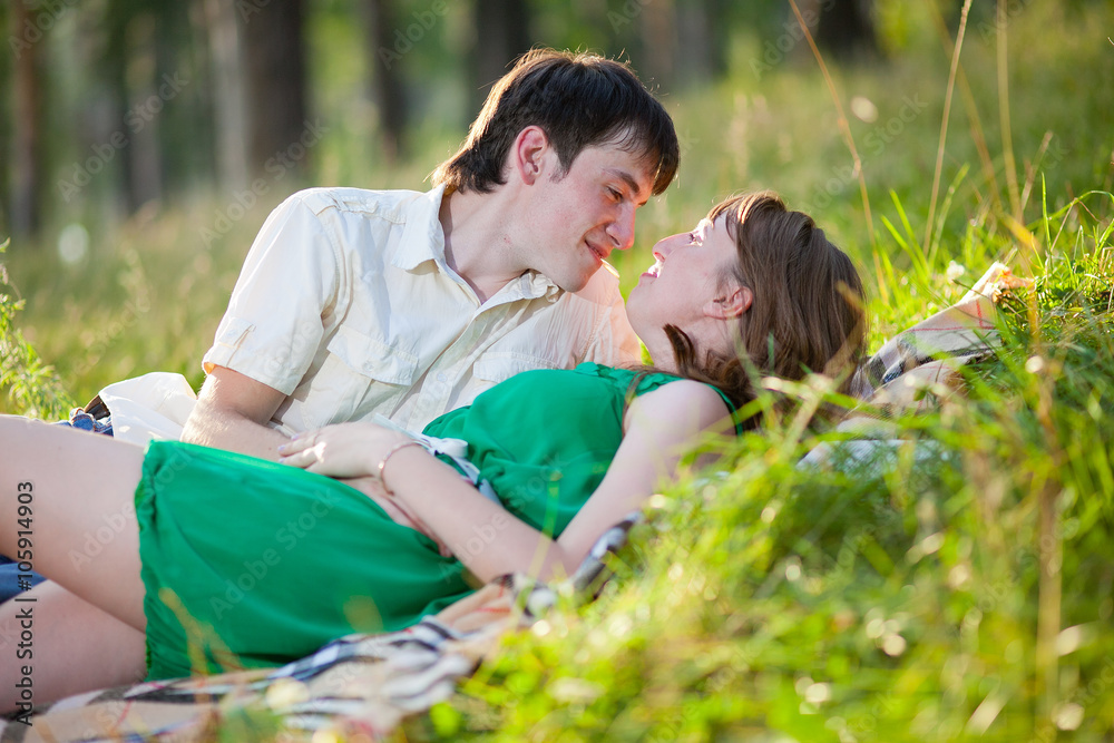 Fototapeta premium Young couple in love outdoor.Stunning sensual outdoor portrait of young stylish fashion couple posing in summer in field