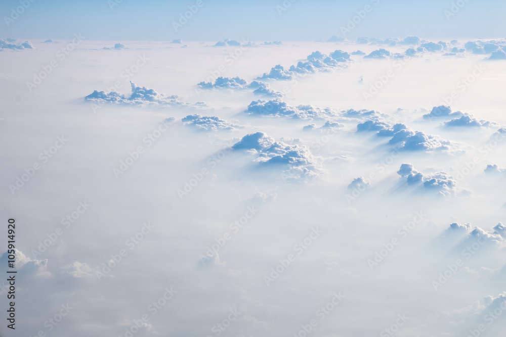 Clouds in blue sky, aerial view from airplane window.