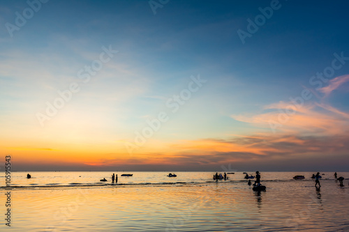 Beautiful sunset at sea beach and people silhouette. © sirins