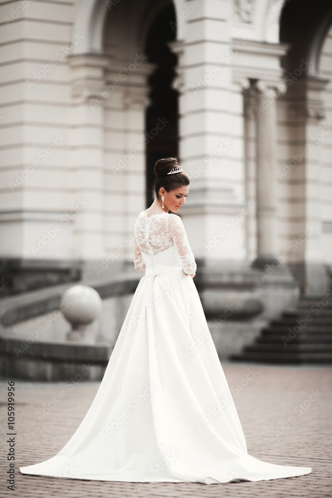 Wonderful bride with a luxurious white dress posing in the old town Wonderful bride with a luxurious white dress posing in the old town