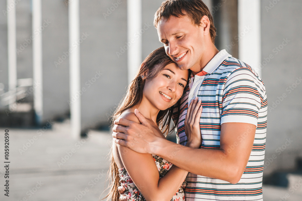The guy embraces his girlfriend during a walk in the fresh air The guy embraces his girlfriend during a walk in the fresh air