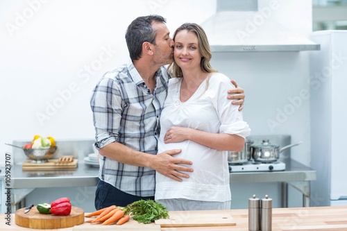 Man kissing on cheek of pregnant woman