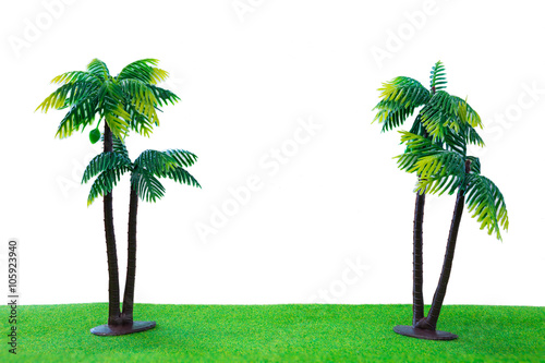 Twic toy coconut tree on grass with isolated white background photo