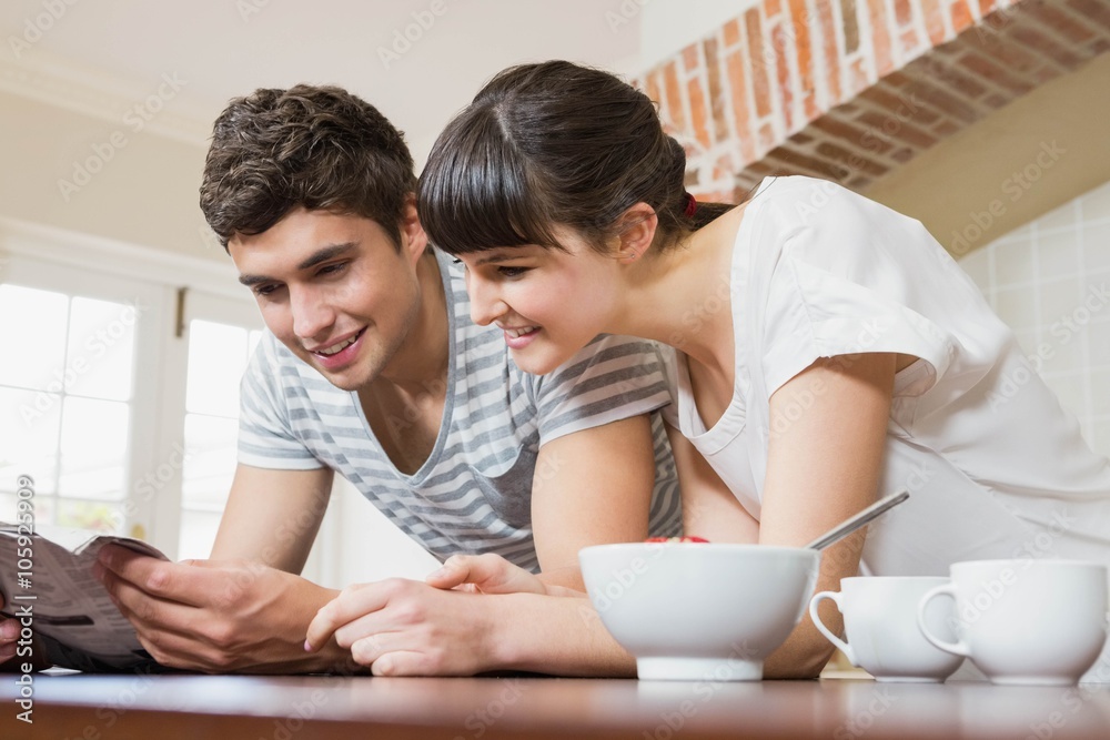 Young couple reading book while having breakfast Young couple reading book while having breakfast