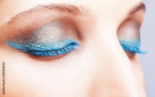 Close-up shot of female closed eyes blue make-up