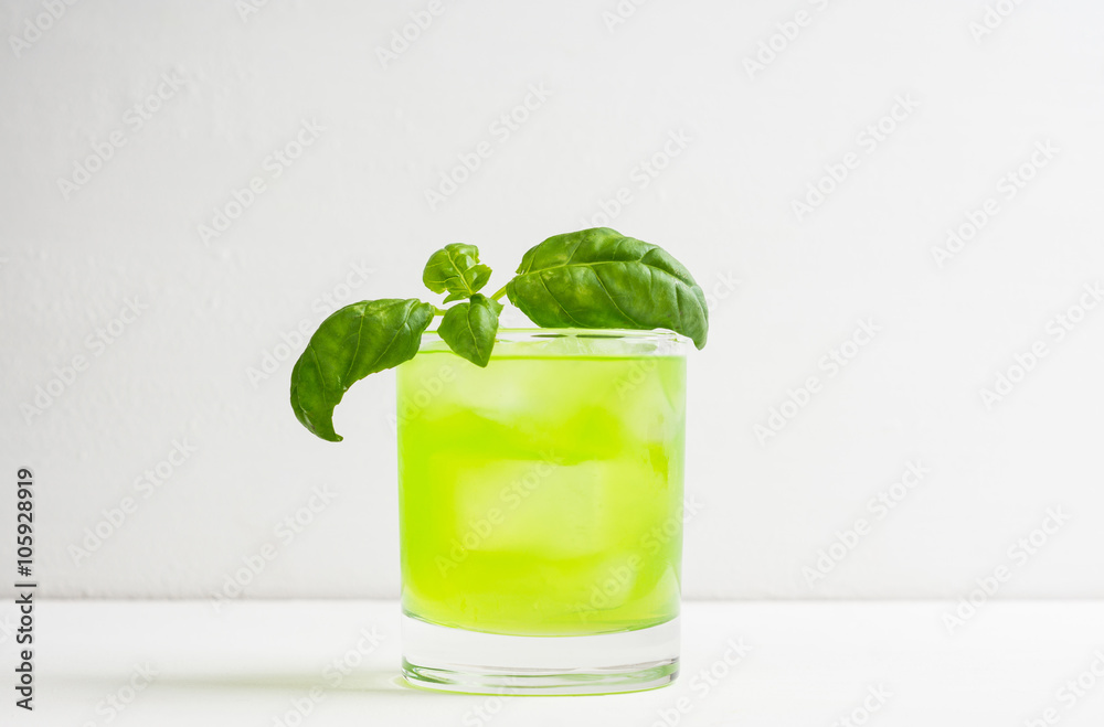 Summer cocktail with basil leaf on the white wooden background Summer cocktail with basil leaf on the white wooden background