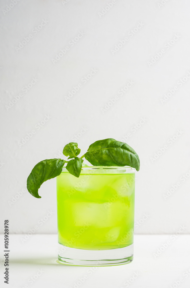 Summer cocktail with basil leaf on the white wooden background Summer cocktail with basil leaf on the white wooden background