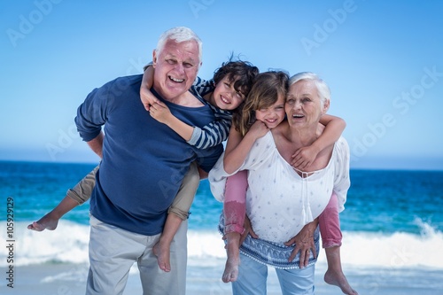 Cuadro en lienzo Happy grandparents giving piggy back to children