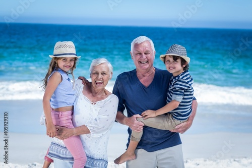 фотографія Happy grandparents giving piggy back to children