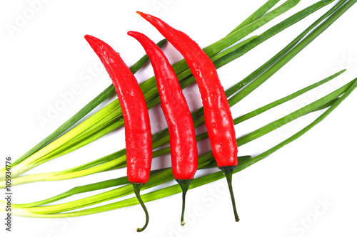Red chili peppers and green onions with water drops isolated on