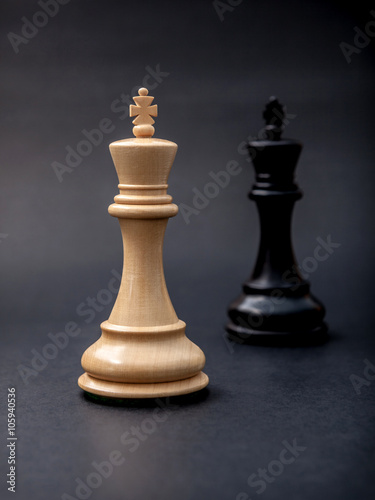 Black and white king of chess set up on dark background .