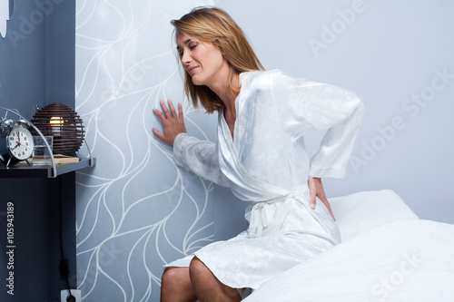 femme qui a mal au dos dans sa chambre photo