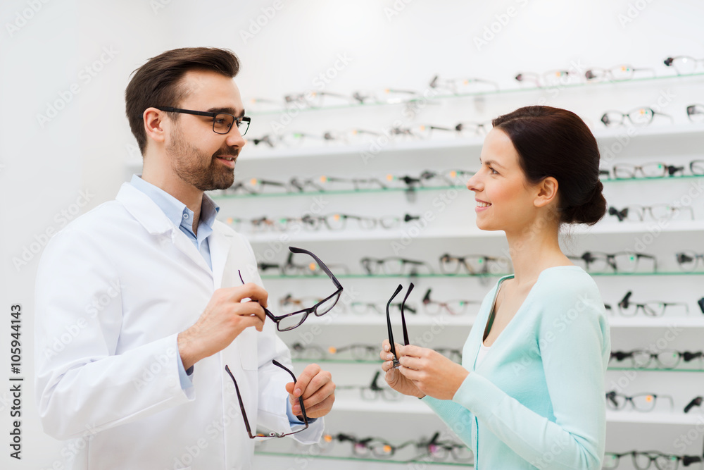 Fototapeta premium woman and optician showing glasses at optics store