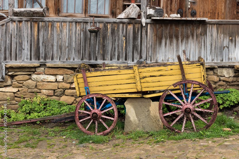 Yellow wooden waggon in front of old house in Jeravna village Yellow wooden waggon in front of old house in Jeravna village
