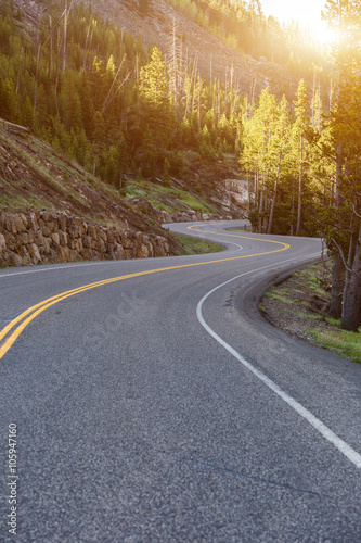 Asphalt road sharp curve along with sunflare in front. Yellowsto photo