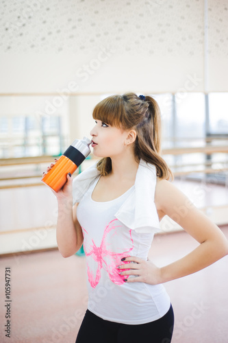 young healthy woman drinking water in fitness