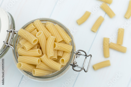 Raw tortiglioni pasta on a glass jar photo