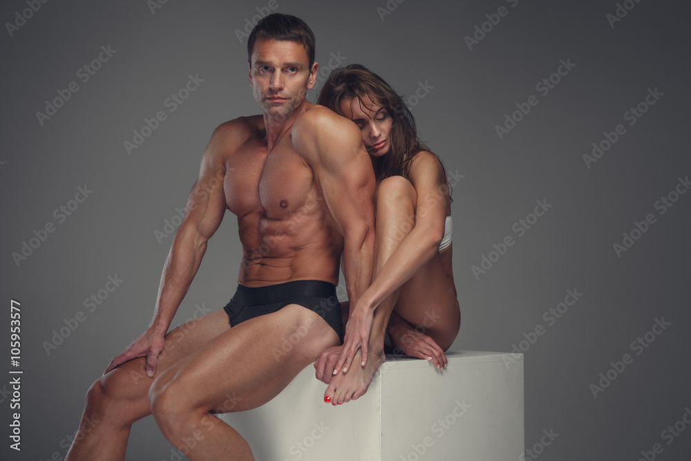 Fitness couple posing in a studio.