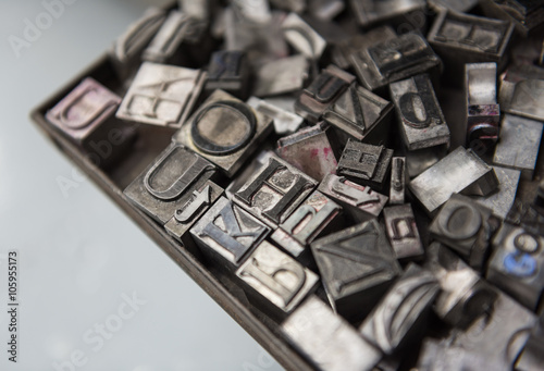 Fototapeta Naklejka Na Ścianę i Meble -  Vintage lead letterpress printing blocks against a weathered metal drawer background with bokeh.