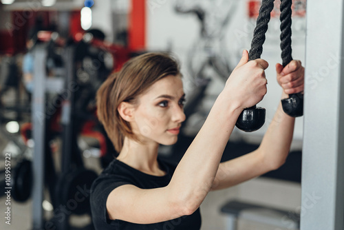 Beautiful girl at the gym on a simulator