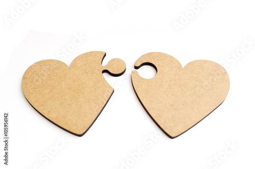 Two wooden hearts in form of puzzle on white background