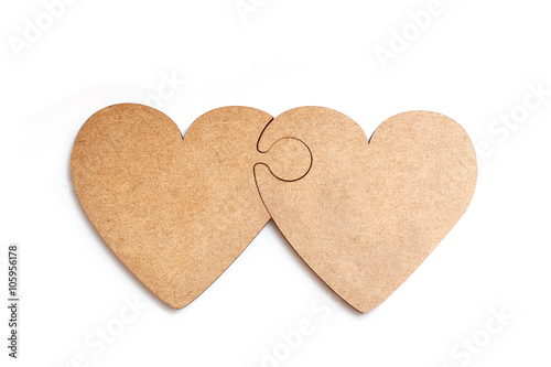 Two wooden hearts in form of puzzle on white background