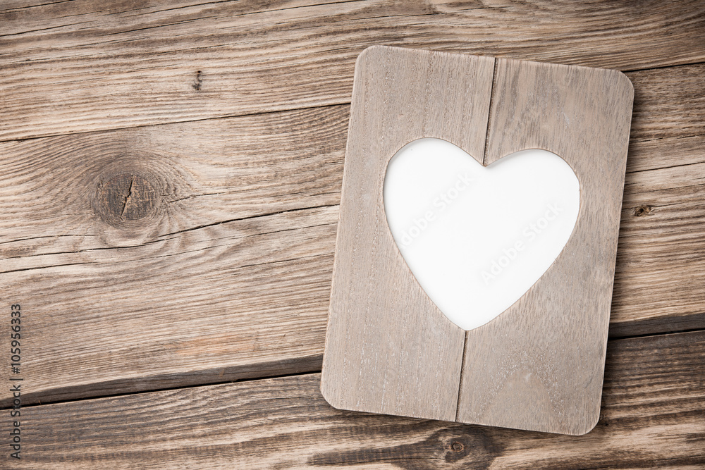 Heart shaped frame on wooden background