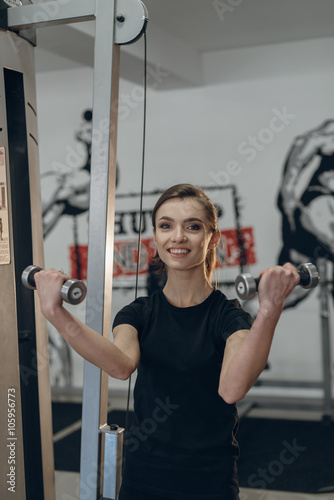 Beautiful girl in the gym with weights
