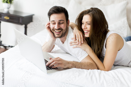 Young couple with laptop in the bed © BGStock72