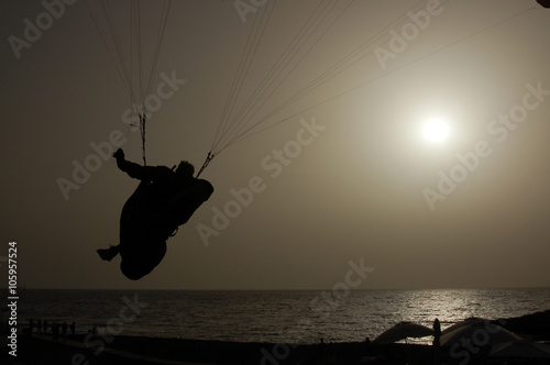 Paragliding backlit flying over a beach in Tenerife