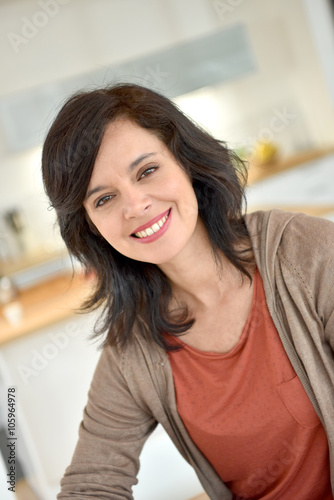 Portrait of smiling 40-year-old woman at home