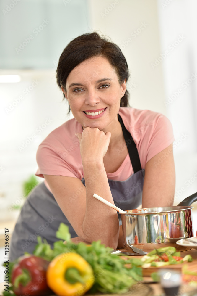 Portrait of beautiful woman cooking in home kitchen Portrait of beautiful woman cooking in home kitchen