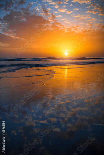 Beach with glossy surface reflecting beautiful seascape on the sunset in Maspalomas on Gran Canaria island