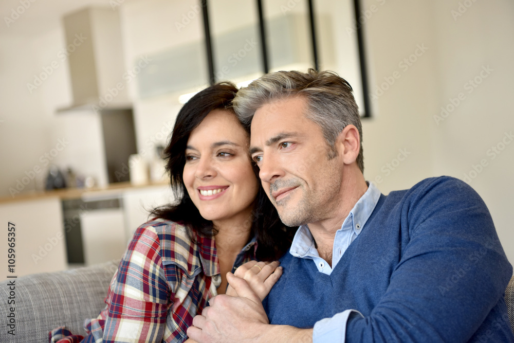 Middle-aged couple relaxing in sofa at home Middle-aged couple relaxing in sofa at home