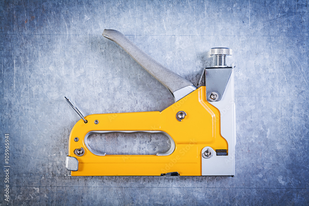 Construction staple on scratched metallic background directly ab Construction staple on scratched metallic background directly ab