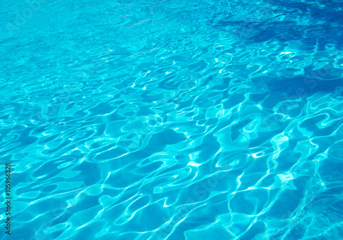 Blue pool water with sun reflections © Pakhnyushchyy