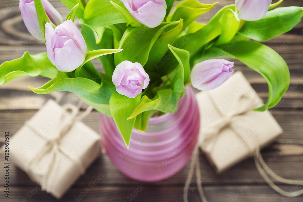 Purple tulips with gifts on the wooden table